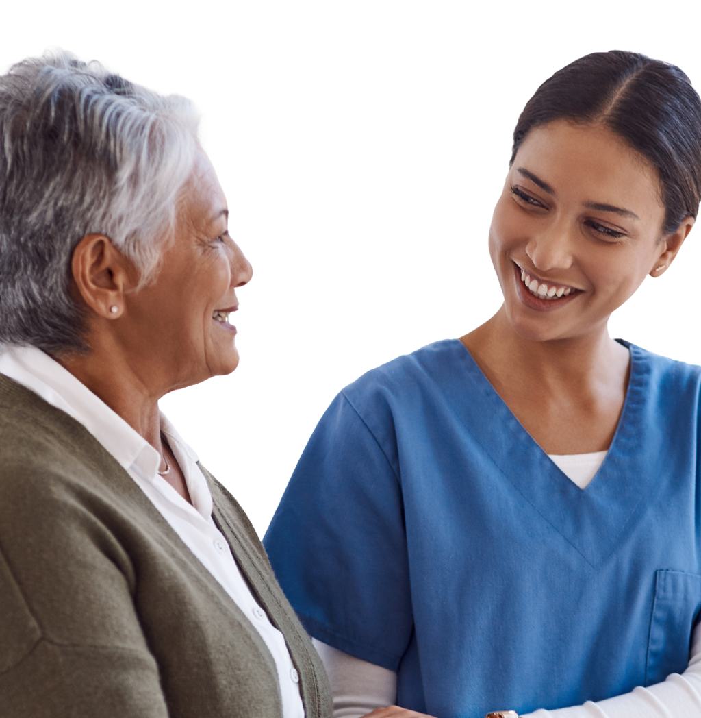 A care worker and an older woman sitting together at home, talking and smiling.