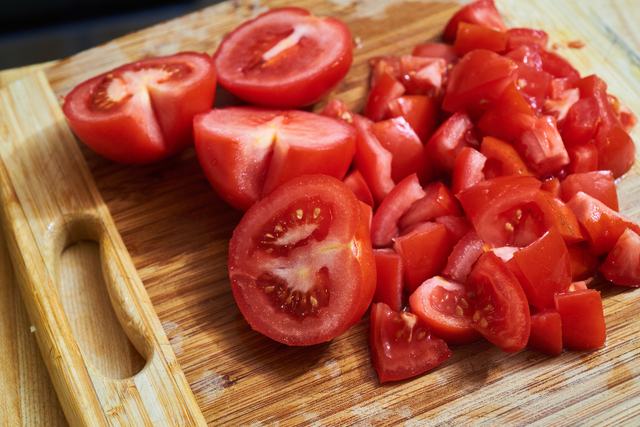 Ripe tomatoes chopped on a wooden board.